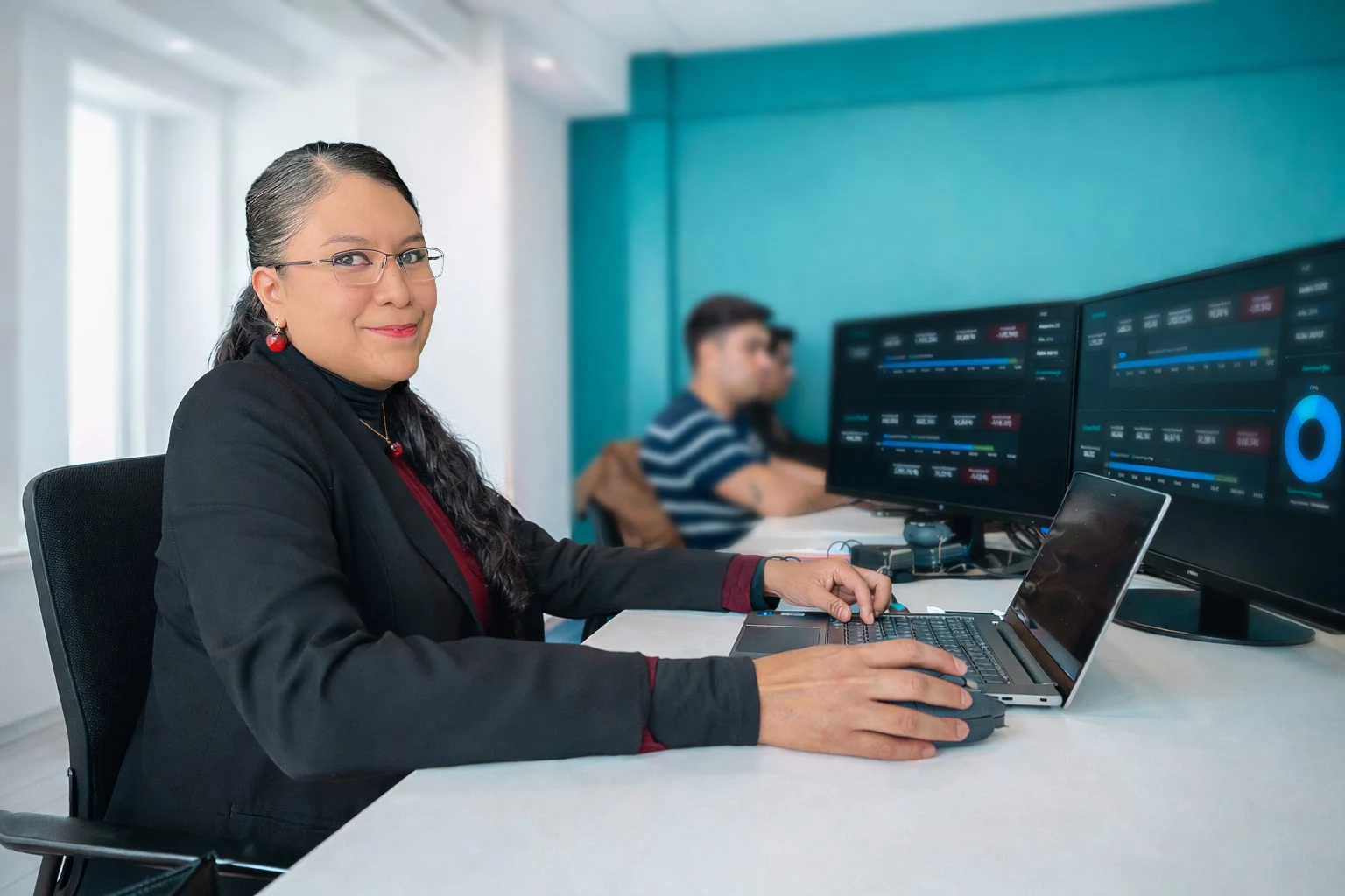 Tania Camacho trabajando frente a monitores con paneles de análisis de datos
