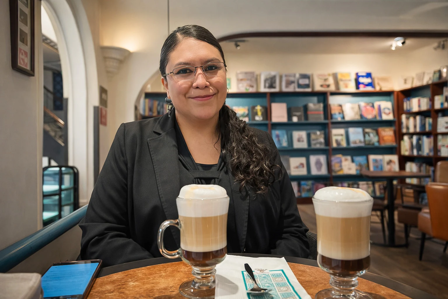 Tania tomando un café en una cafetería con espacio cultural